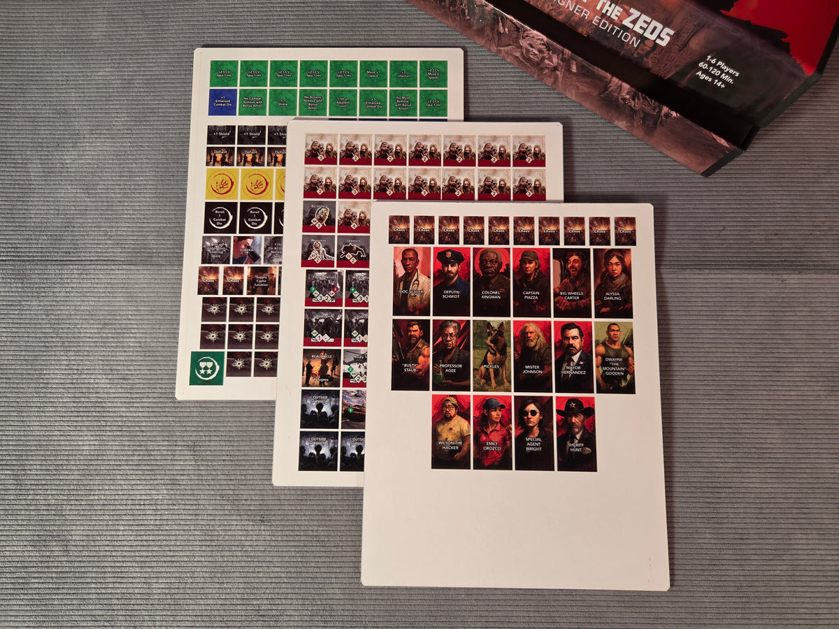Collection of game counters on a grey surface, from "Dawn of the Zeds" game.