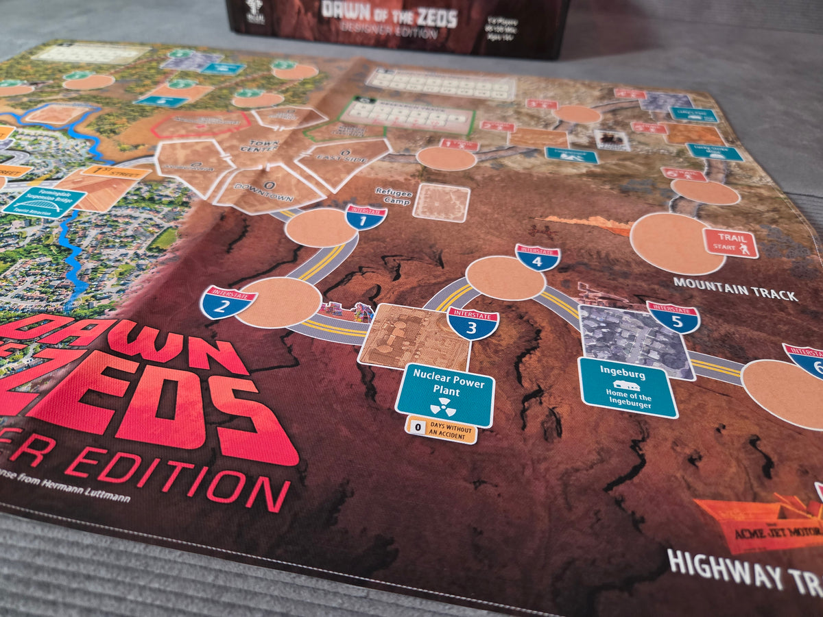 Board game mat with 'Dawn of the Zeos' branding on a gray surface