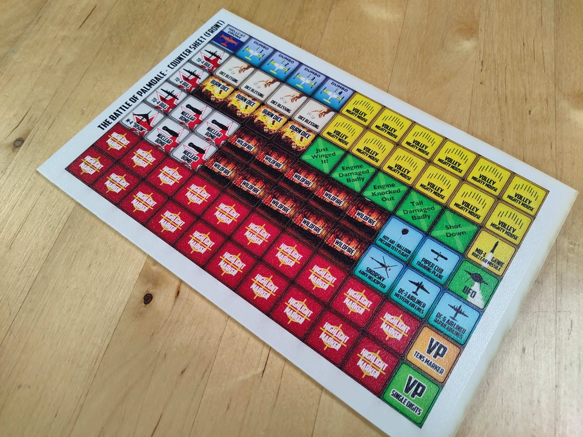 Colorful board game mat with various symbols on a wooden surface