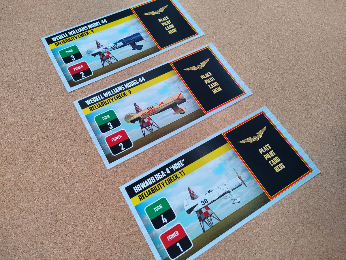 Three model airplane cards on a brown surface.