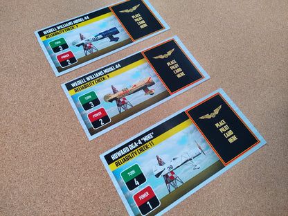 Three model airplane cards on a brown surface.