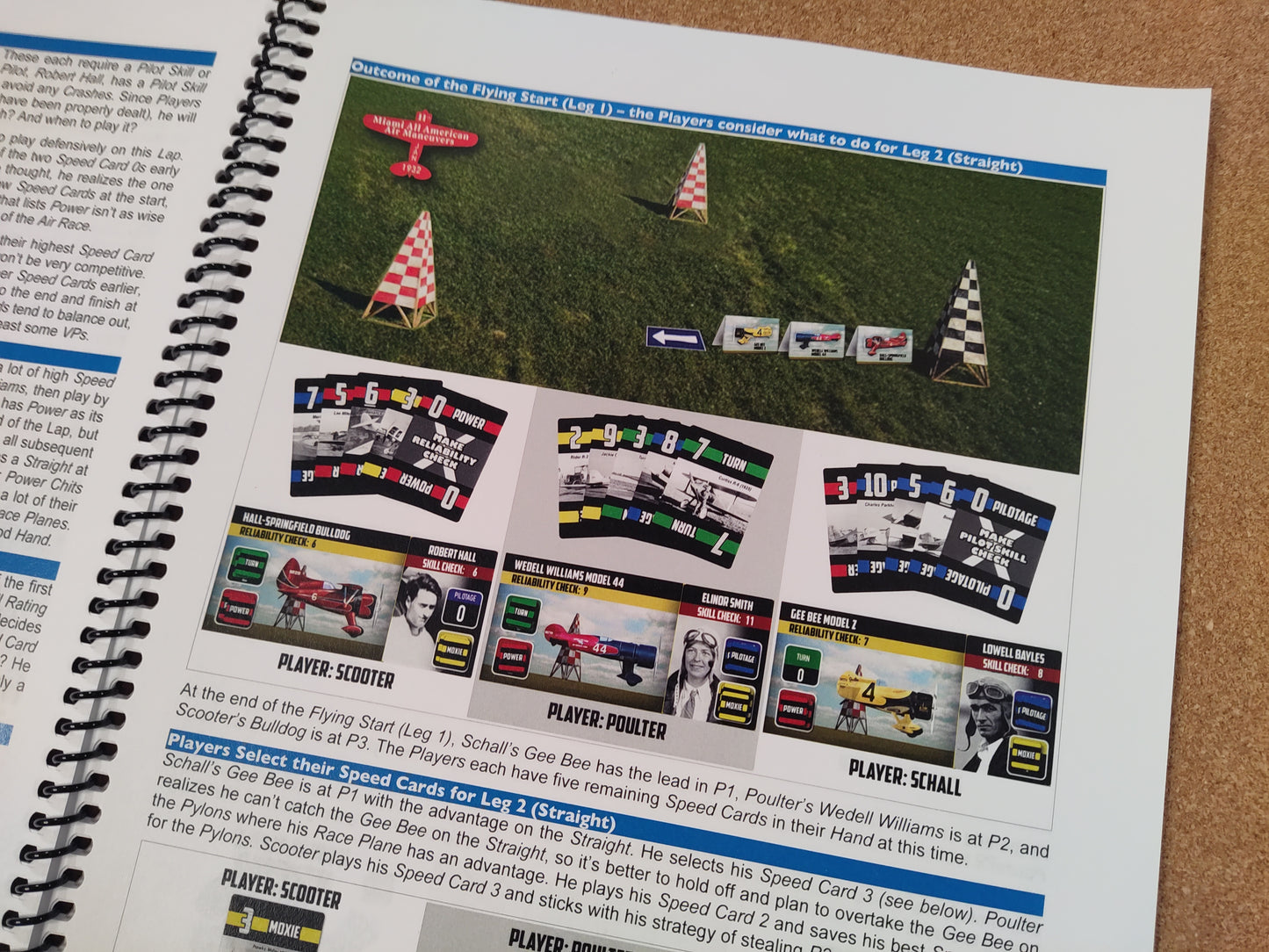 Spiral-bound book with a page showing race plane graphics and text on a cardboard surface.