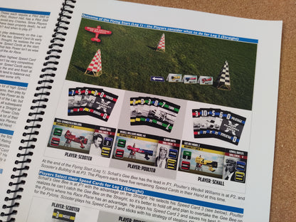 Spiral-bound book with a page showing race plane graphics and text on a cardboard surface.