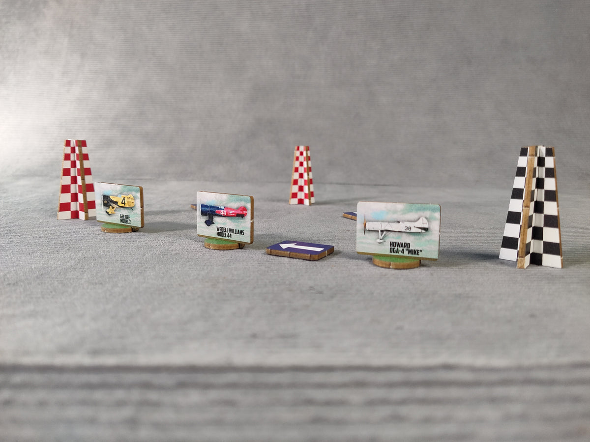 Model race track with planes and checkered flags on a gray surface.